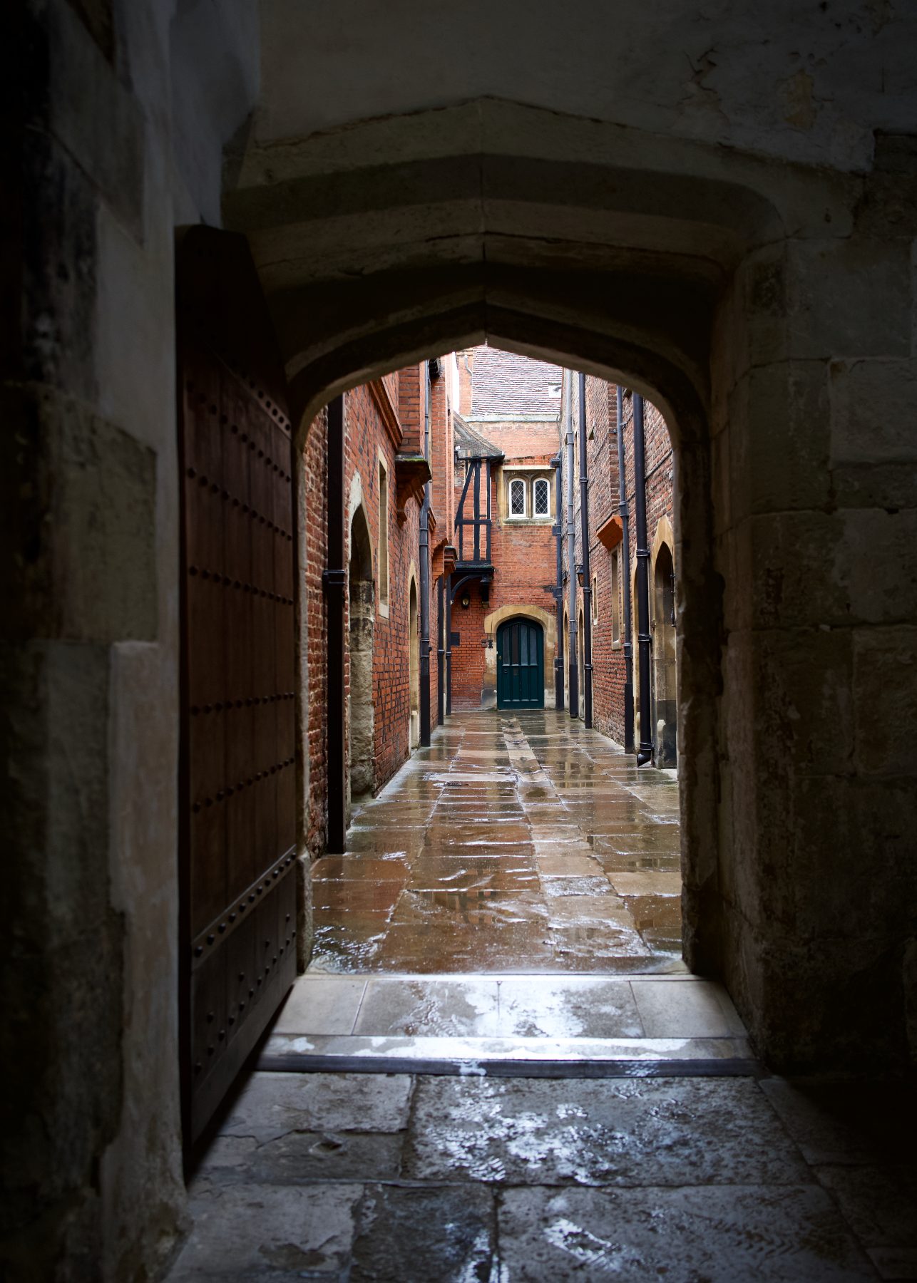 A stone doorway through to a brick hallway at Hampton Court Palace.